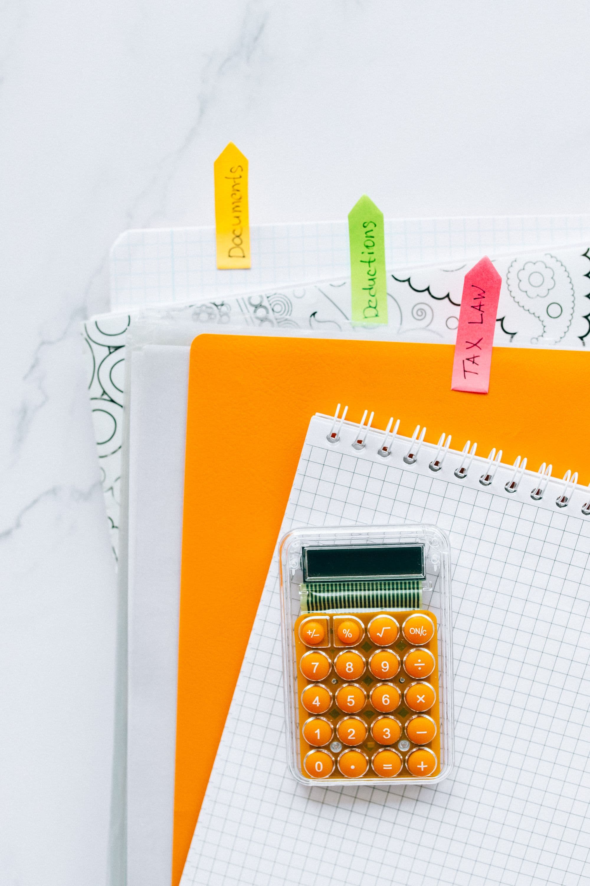 Calculator resting on a stack of financial documents