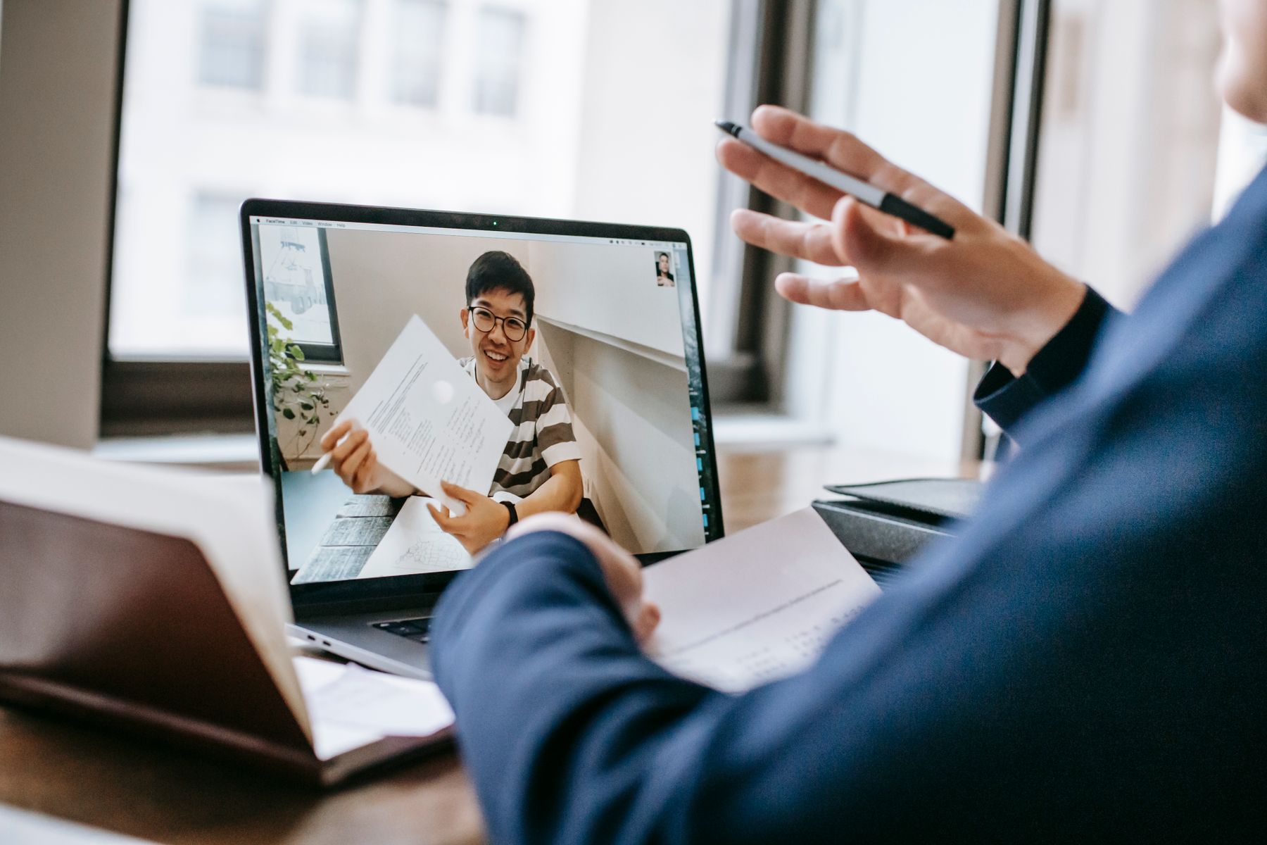 Accountant on a video call reviewing documents with a colleague