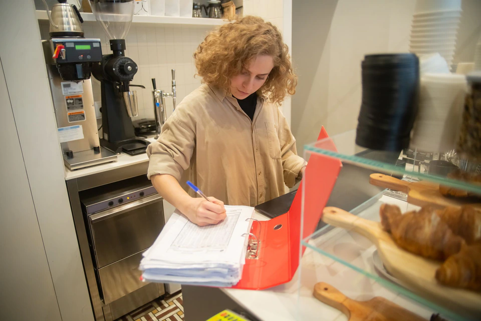 A café owner going through paperwork at the counter